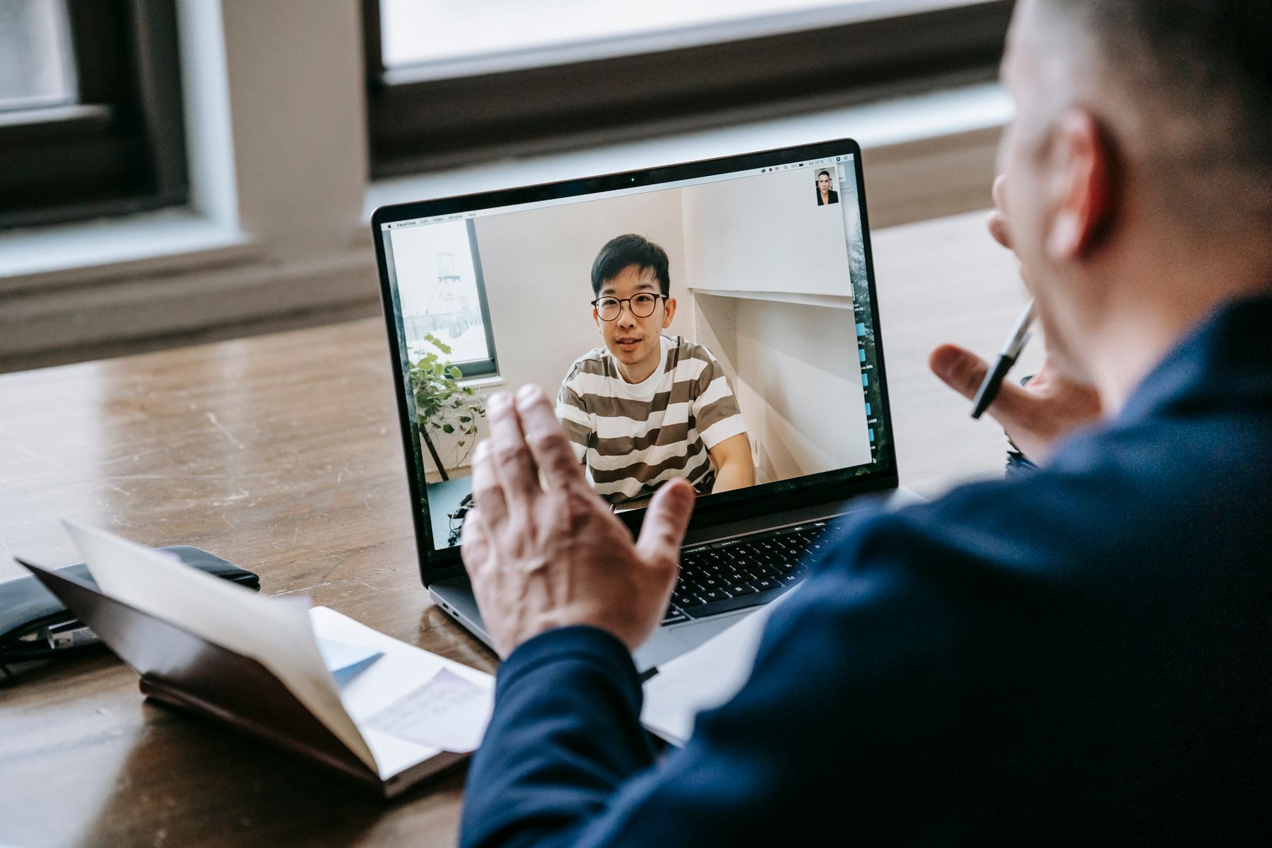 Professional participating in a remote video meeting on a laptop